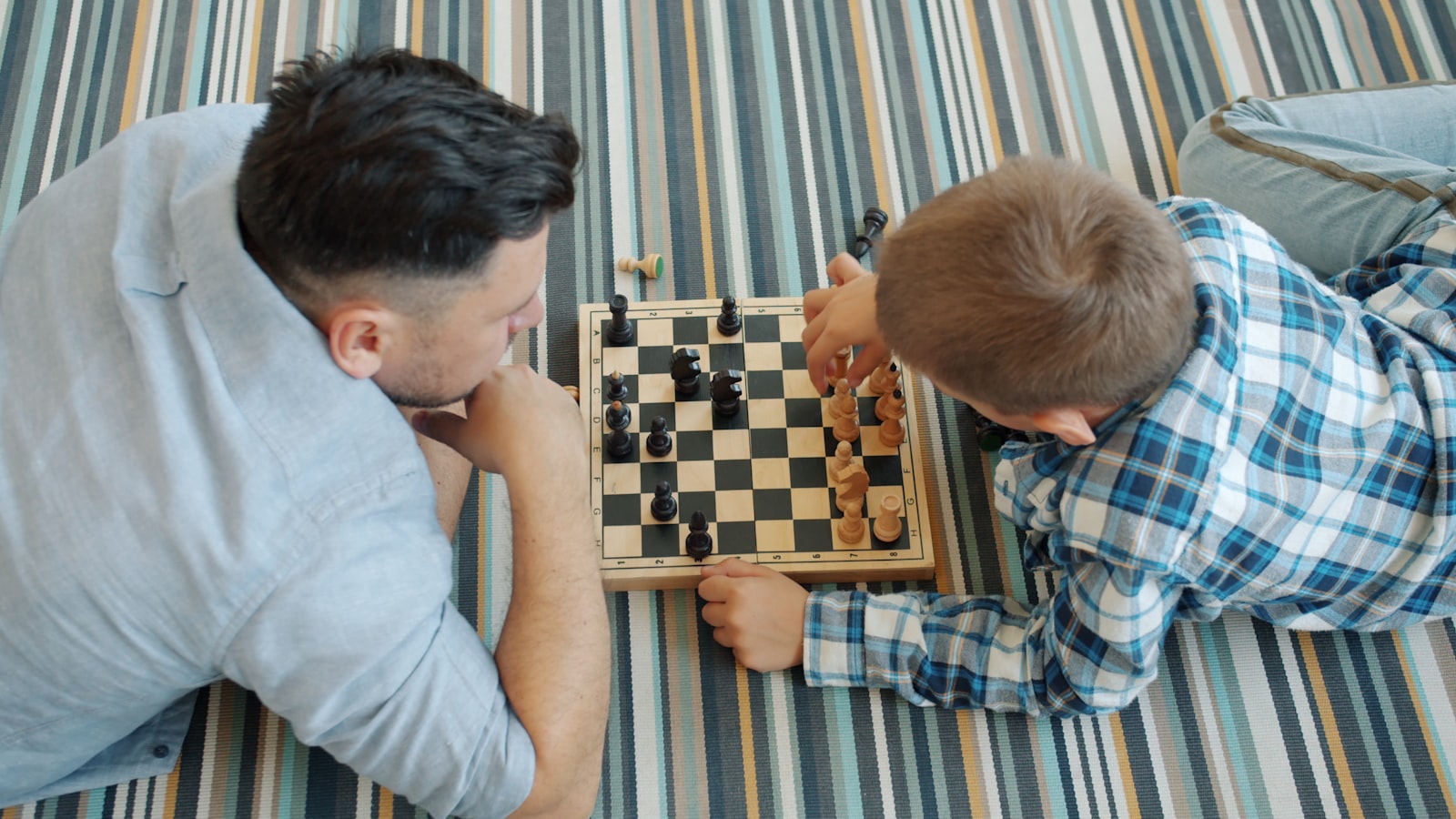 Father and child playing a strategy game together on the floor