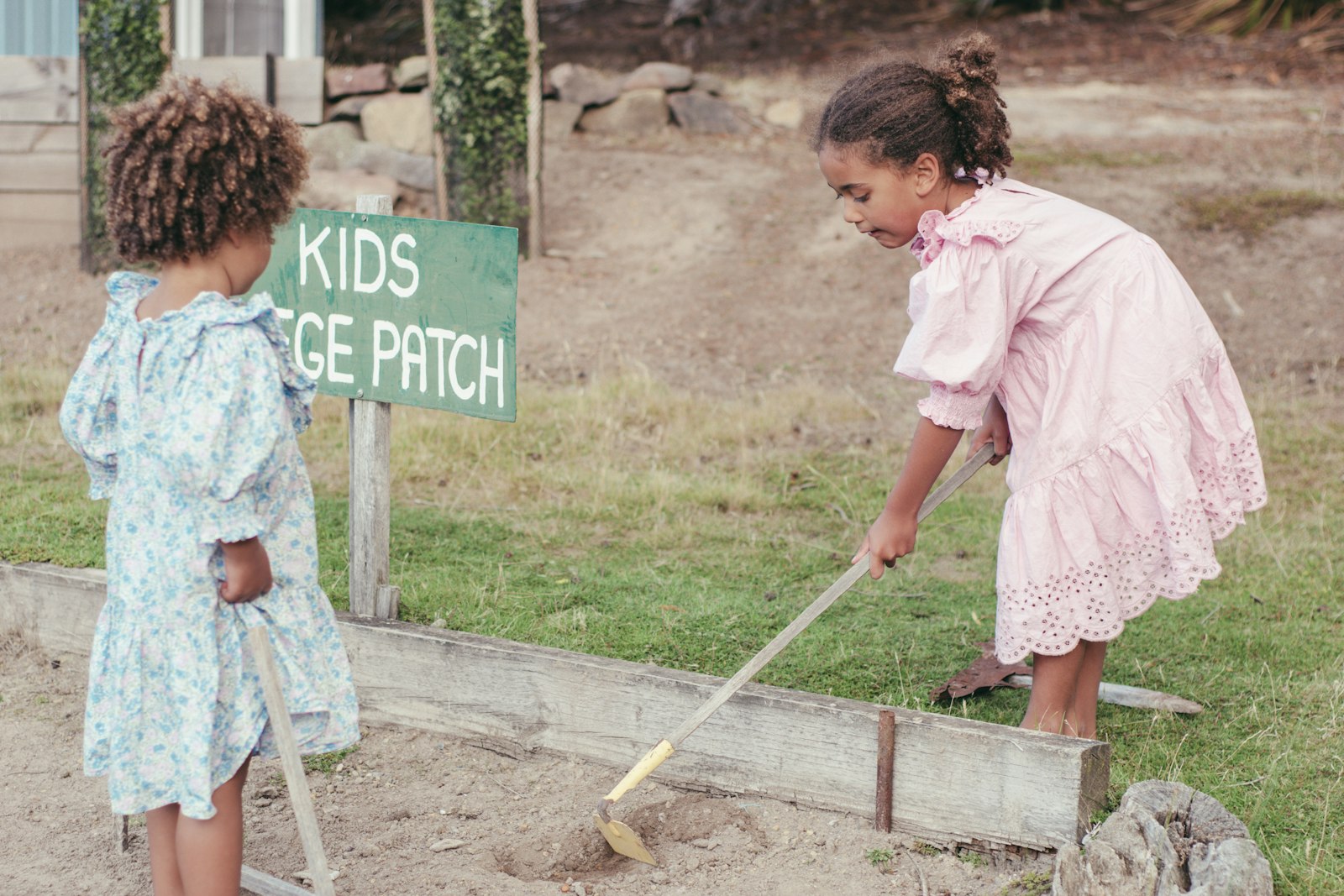 Two girls working together outside cleaning up the yard